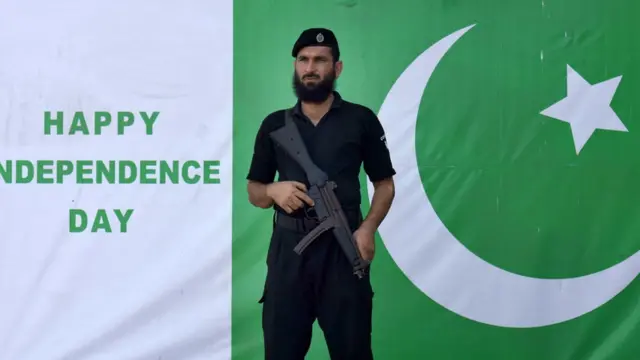 Askari Pakistani ah ayaa hor taagan calanka dalkiisa magaalada Peshawar ee Pakistan.