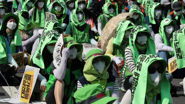 불볕더위에 얼굴 감싼 집회참가자들