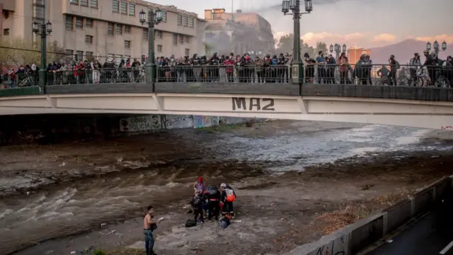 Voluntarios asisten al menor caído a río Mapocho.