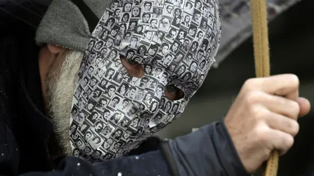 Persona con fotos de los desaparecidos.