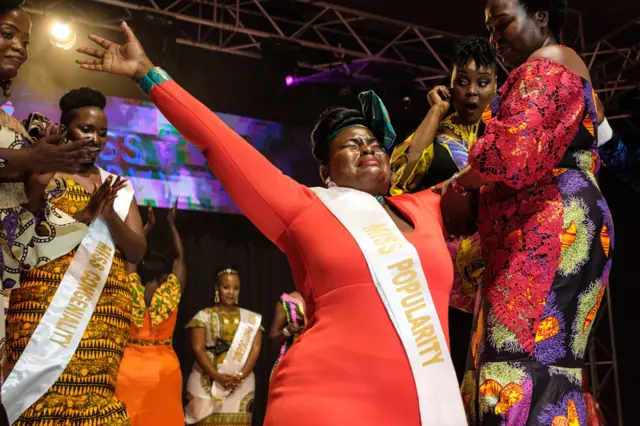 Nasasi Belinda (katikakati), mwanamke mfanyabiashara allijawa na hisia na kutokwa na machozi alipovishwa taji la mwanamke mwenye maumbo makucrowned Miss Curvy Uganda during the first edition of Miss Curvy Uganda in Kampala, Uganda, on April 26, 2019.