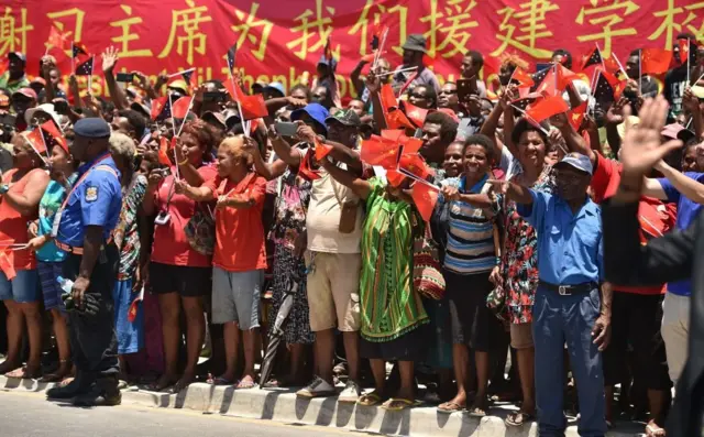 2018年11月16日，巴布亚新几内亚儿童手举中国和巴新国旗，欢迎习近平访问。