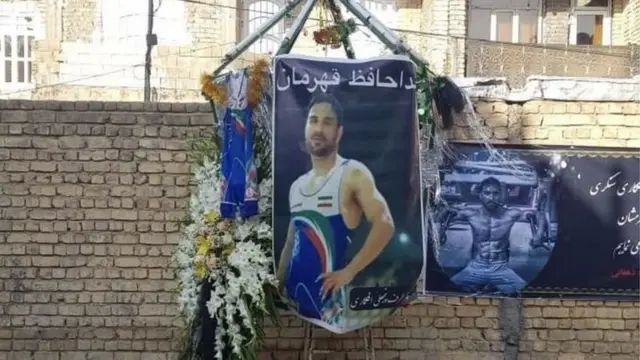 تصویری از مقابل خانه نوید افکاری بعد از مرگش. دوبنده کشتی او را هم کنار تصویرش آویزان کرده‌اند