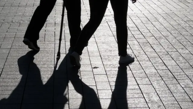 Pareja caminando y sus sombras.