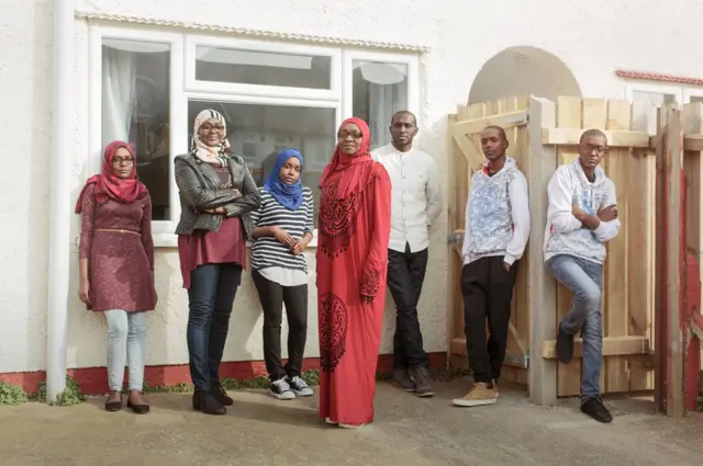 أسرة تقف خارج المنزل.