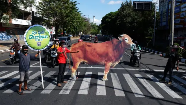 Sejumlah relawan membawa replika sapi saat aksi kampanye berkurban di Jalan Slamet Riyadi, Solo, Jawa Tengah, Rabu (29/7/2020). Aksi itu digelar untuk mengajak masyarakat melaksanakan ibadah berkurban di Hari Raya Idul Adha 1441 H.