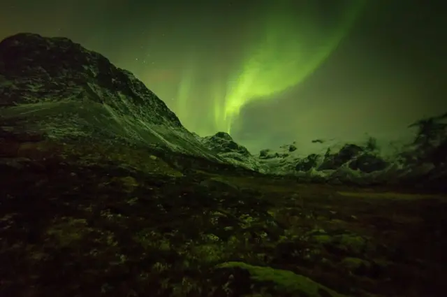 صورة للأضواء الشمالية من فوق الجبل