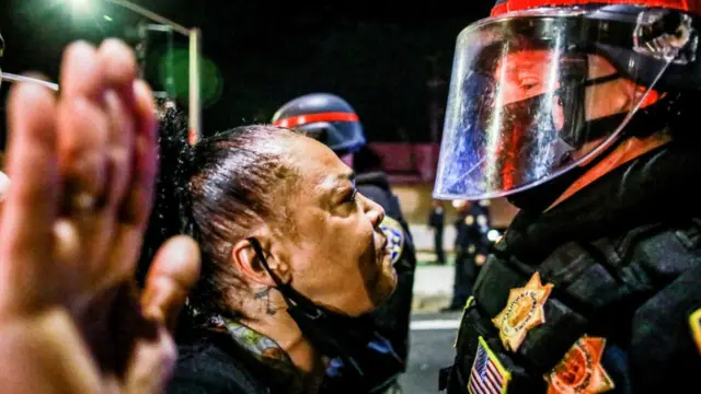 Um manifestante fica cara a cara com um policial