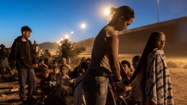 Inmigrantes venezolanos que solicitan asilo en Estados Unidos esperan a ser procesados por agentes fronterizos estadounidenses tras cruzar desde México el 08 de mayo de 2023 en El Paso, Texas.