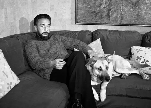 El escritor sentado junto a un perro.