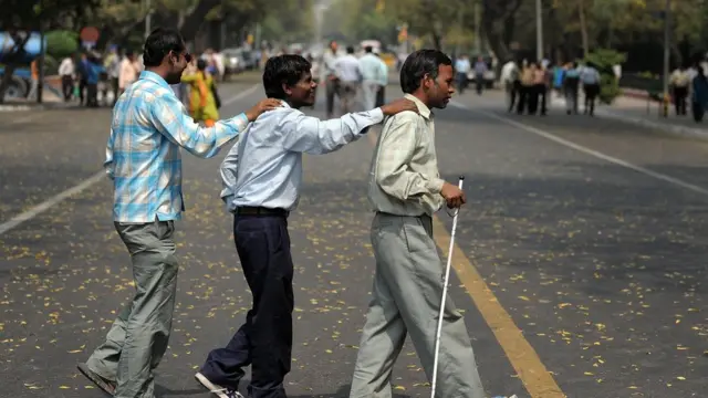 రోడ్డు దాటుతున్న అంధులు