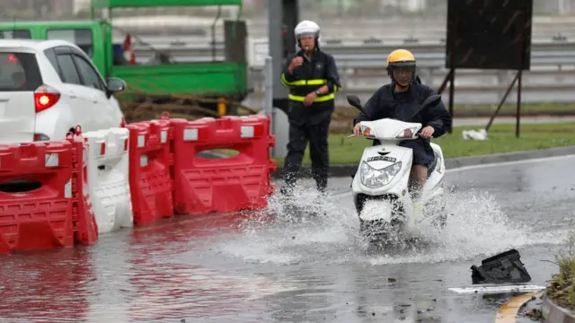 澳門一名男子騎著摩托車開過略有積水的馬路（27/8/2017）