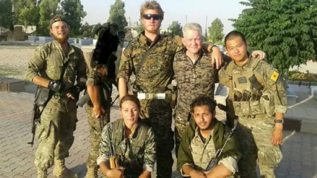 مايكل إنرايت مع مجموعة من المقاتلين الأجانب في صفوف وحدات حماية الشعب الكردية في سوريا
