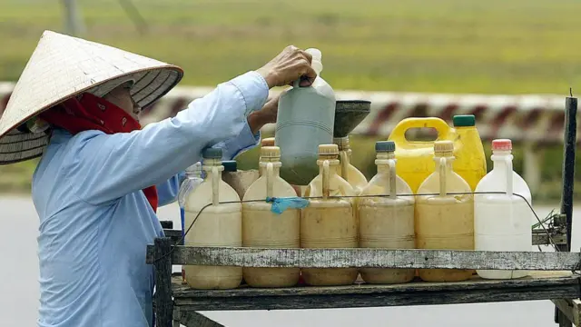 Một phụ nữ bán xăng bên lề đường