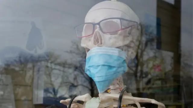 કોરોના વાઇરસને પગલે યુકેમાં એક મેડિકલ શૉપની બહાર હાડપિંજર સાથે માસ્ક મૂકવામાં આવ્યું છે.