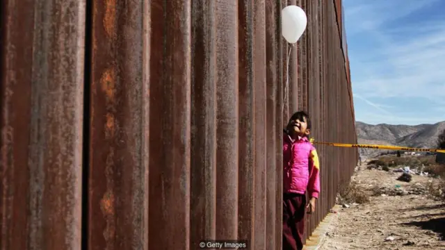 Một cô gái cầm một quả bóng bay tại bức tường giữa Mexico và Mỹ ở Ciudad Juárez, vào ngày mà các gia đình bị bức tường chia cắt được đoàn tụ trong ba phút
