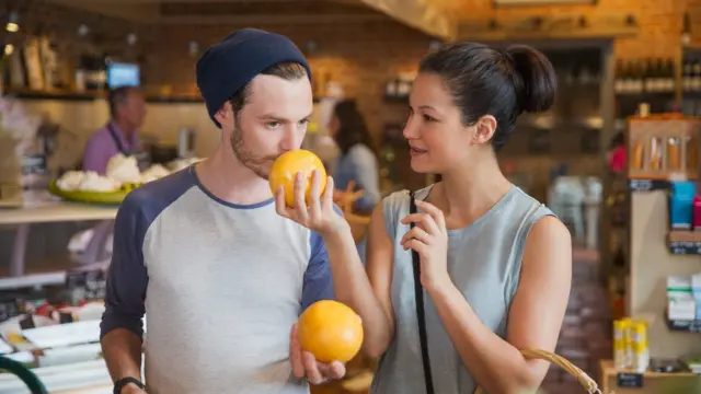 Casal cheirando frutas no mercado