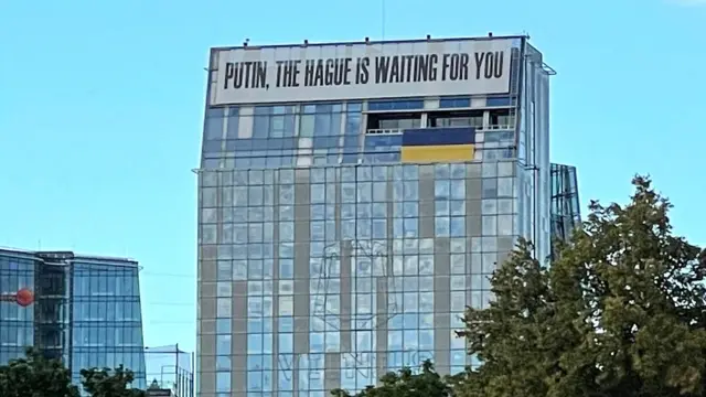 Spanduk di gedung yang terletak di jantung ibu kota Vilnius, Lithuania: "Putin, Den Haag menunggu Anda."