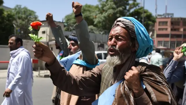 Peace activist holds a flower as he marches from Helmand to Kabul demanding the government and the Taliban call a ceasefire