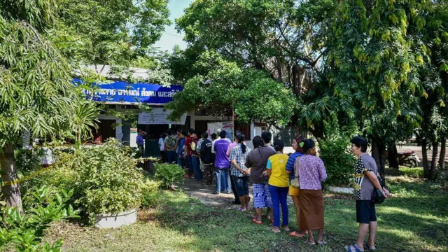Buriram'da oy verme merkezinde seçmenler kuyrukta beklerken görülüyor.