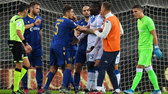 Mario Balotelli being contained by team mates and opponents