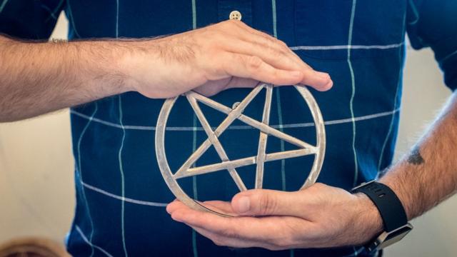 Manos de hombre sujetando una estrella de cinco puntas símbolo de la religión wicca