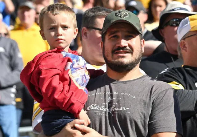 Un padre con su hijo ven un partido de la liga universitaria entre los Northwestern Wildcats y los Iowa Hawkeyes el 29 de octubre de 2022 en el Kinnick Stadium, Iowa City, Estados Unidos.