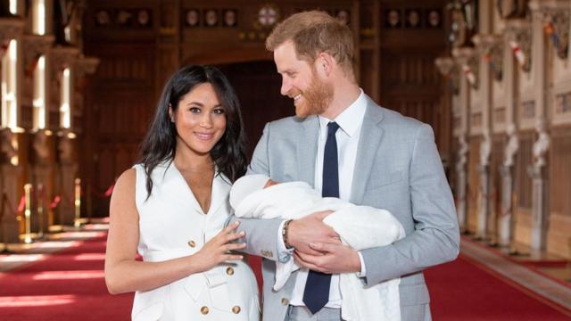 Prince Harry, Duke of Sussex (R), and his wife Meghan, Duchess of Sussex, pose for a photo with their newborn baby son in St George"s Hall at Windsor Castle in Windsor, west of London on May 8, 2019