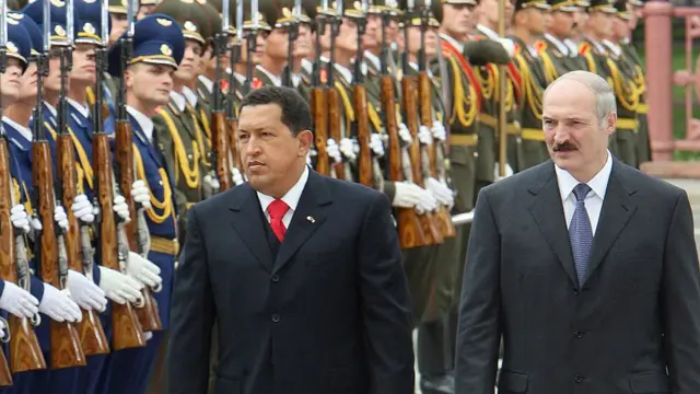 Hugo Chávez e Aleksandr Lukashenko caminham durante cerimônia, rodeados por militares