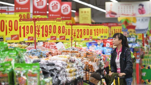 A woman purchases snacks at a supermarket on May 10, 2018 in Taiyuan, Shanxi Province of China