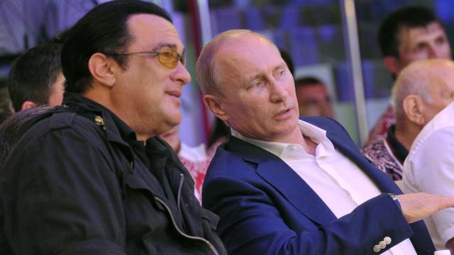 Steven Seagal sits with Russian President Vladimir Putin during a fighting championship in 2012