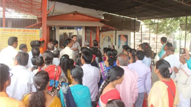 अयोध्या में मंदिर का मॉडल देखते भक्त