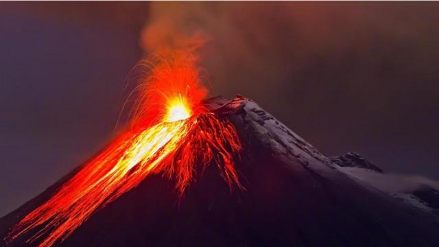 Una foto nocturna de un volcán haciendo erupción