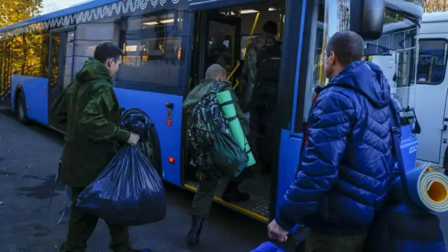 Des hommes montent dans des bus après leur recrutement à Moscou