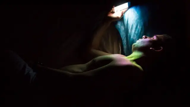 Мужчина с телефоном в постели