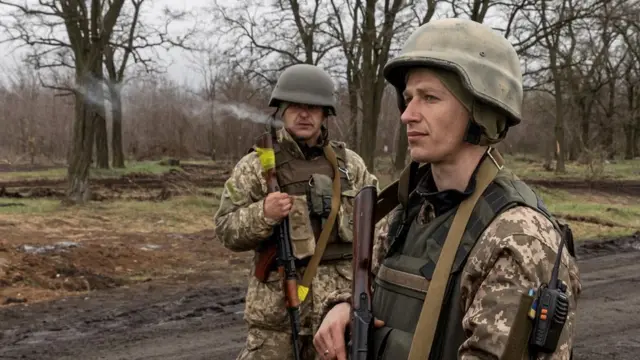 Ukrainian soldiers stand at their position outside the village of Barvinkove, Kharkiv region