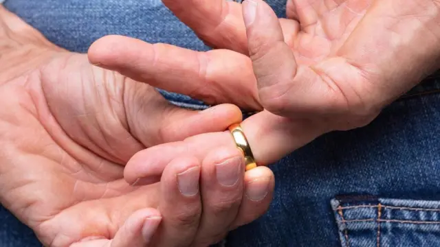 Hombre quitándose anillo de casado.