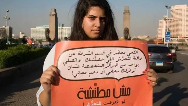 فتاة ترفع لافتة ضد التحرش