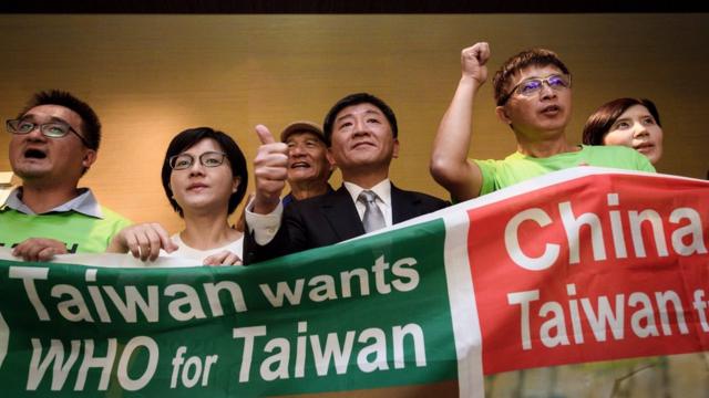 Taiwan's health Minister Chen Shih-chung (C) gives a thumb up as he poses with demonstrators after a press conference on the sideline of the World Health Organization annual Assembly on May 21, 2018 in Geneva.