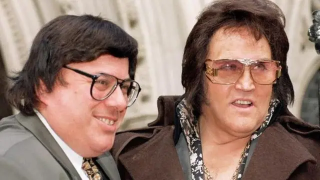 سيد شو (يسار) يبيع تذكارات ذات صلة بنجم الروك آند رول إلفيس بريسلي