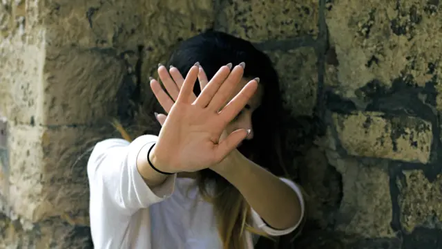 Mujer hace gesto de rechazo