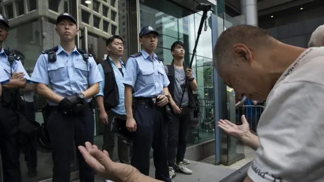 便装警员在一列军装警员身后举起摄录机拍摄示威者(21/6/2019)