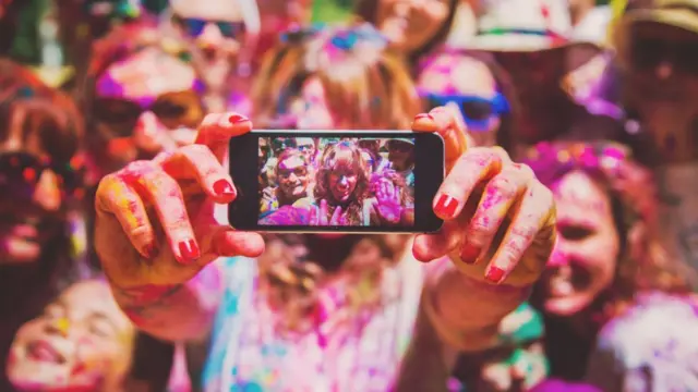 Um grupoamigos tirando fotos enquanto estãouma festa