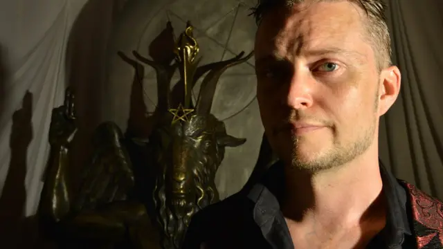 Msemaji wa Satanic Temple akiwa na sanamu ya Baphomet