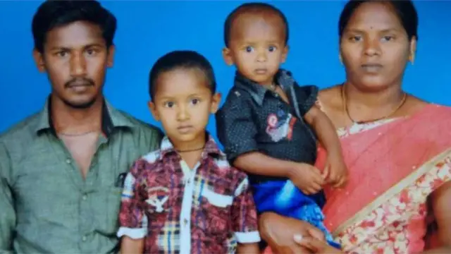 Sujith on his mother's arm with his brother and father
