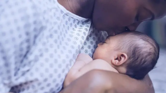 Mãe beija seu bebê no hospital