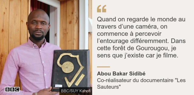 Abou Bakar Sidibé posant avec l'une des nombreuses distinctions du documentaire "Les Sauteurs"