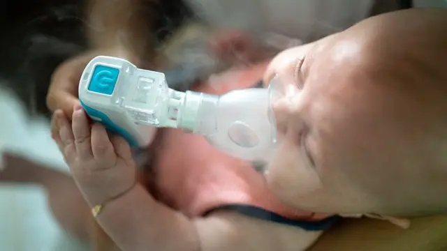 Um bebê com uma máscaraaprender a fazer apostas desportivasnebulização