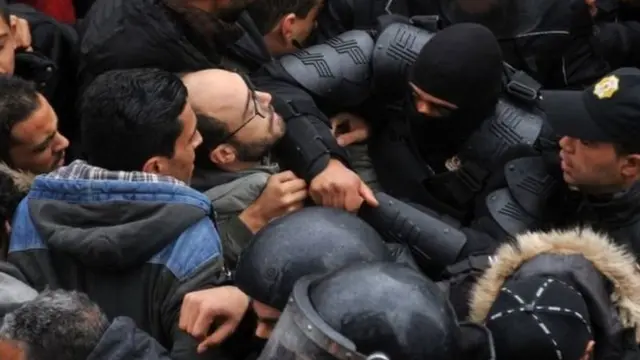 Une foule de manifestants contenue par des agents des forces de l'ordre, en Tunisie (photo d'archives).