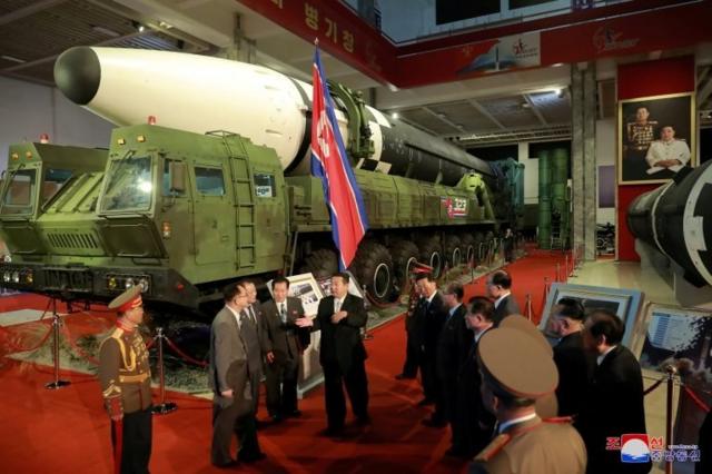 North Korea"s leader Kim Jong Un speaks to officials next to military weapons and vehicles on display, including the country"s intercontinental ballistic missiles (ICBMs), at the Defence Development Exhibition, in Pyongyang, North Korea, in this undated photo released on October 12, 2021 by North Korea"s Korean Central News Agency (KCNA)